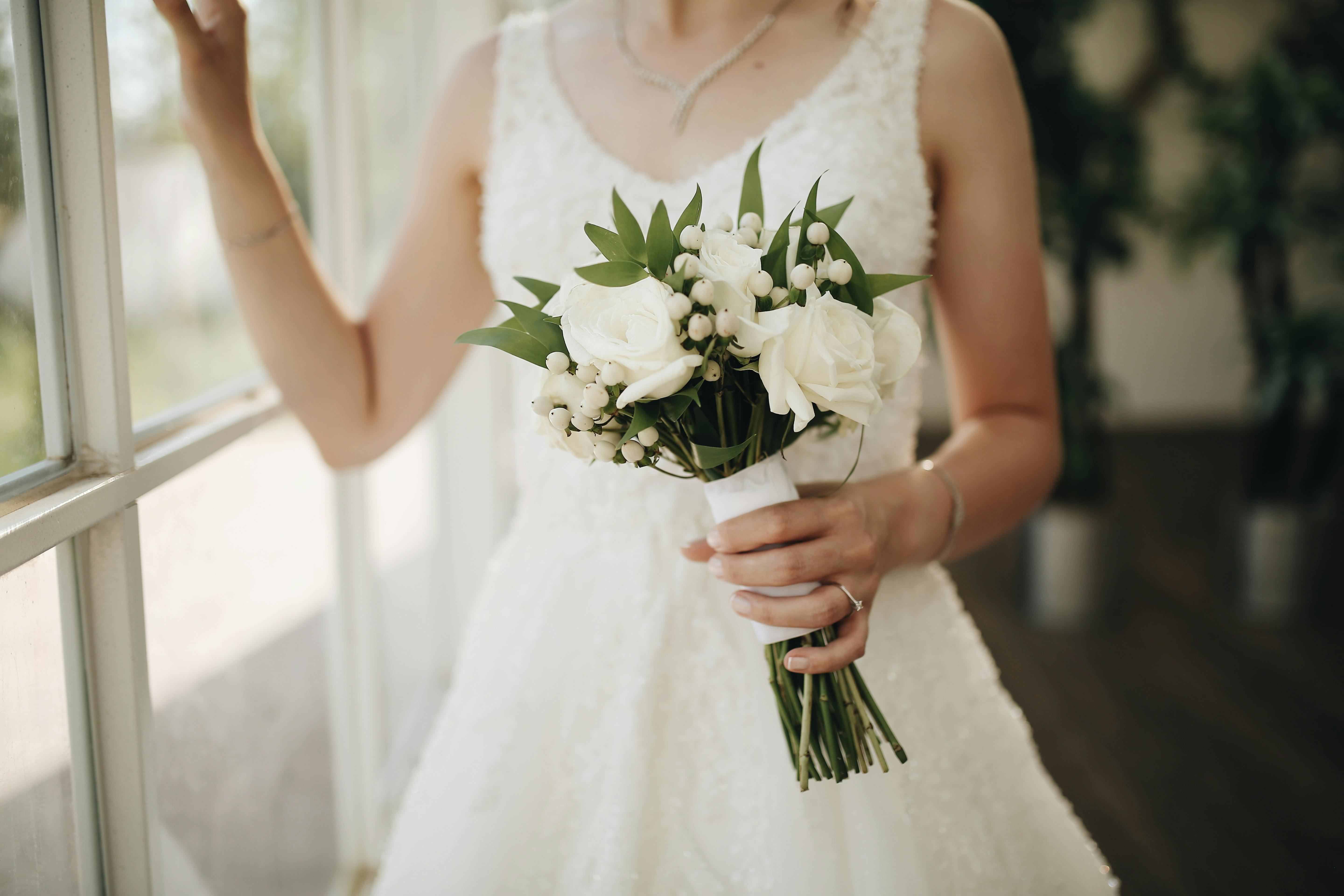Braut mit modernem weissem Bouquet und eleganten Accessoires